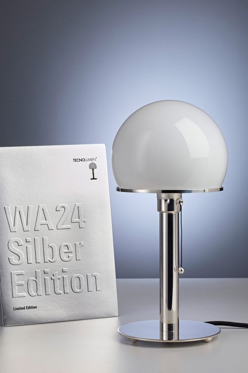 Wilhelm Wagenfeld entwarf das erste Modell seiner Tischleuchte nach einer von Moholy-Nagy gestellten Aufgabe in der Metallwerkstatt. Sie war als Industrieprodukt gedacht, also maschinell und in Serie produzierbar. Tatsächlich vermittelten Material und Formensprache nur den Eindruck — die Leuchte war handgefertigt. Zum Jubiläum gibt es den Klassiker nun erstmals als limitierte Silberedition. Tecnolumen.