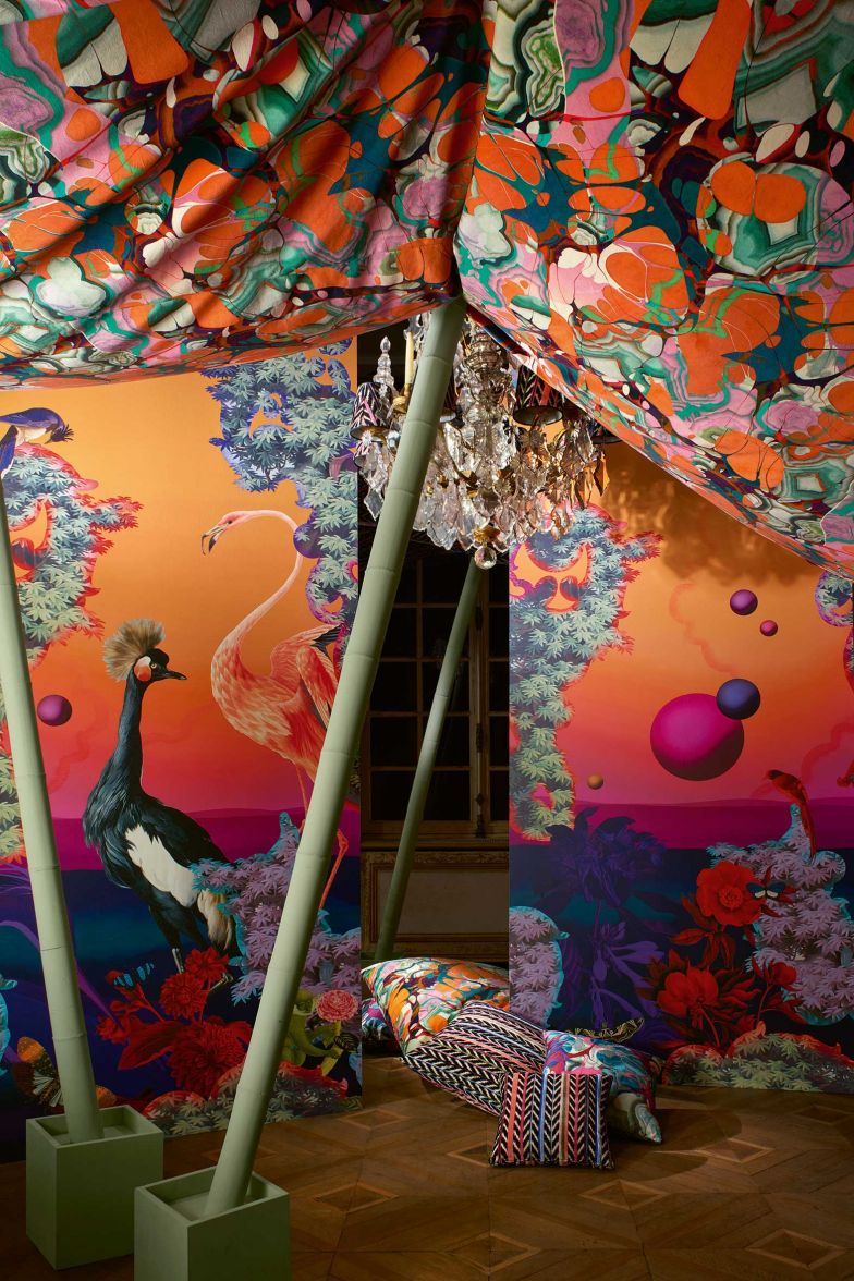 Es sei eine Kollektion, die alle Kulturen und Landschaften des Südens zelebriere, beschreibt der Creative Director Sacha Walckhoff die neue Christian Lacroix Maison-Kollektion «Stravaganza»; eklektisch, extravagant und ein Kaleidoskop aus Farben, Formen und Materialien. Im Bild: Stoff «Kaoscope» mit grossflächig marmorierten Formen, die auf einen Baumwollsatin gedruckt sind. Im Hintergrund Tapete »Novafrica Sunset Scene 2». DESIGNERSGUILD.COM