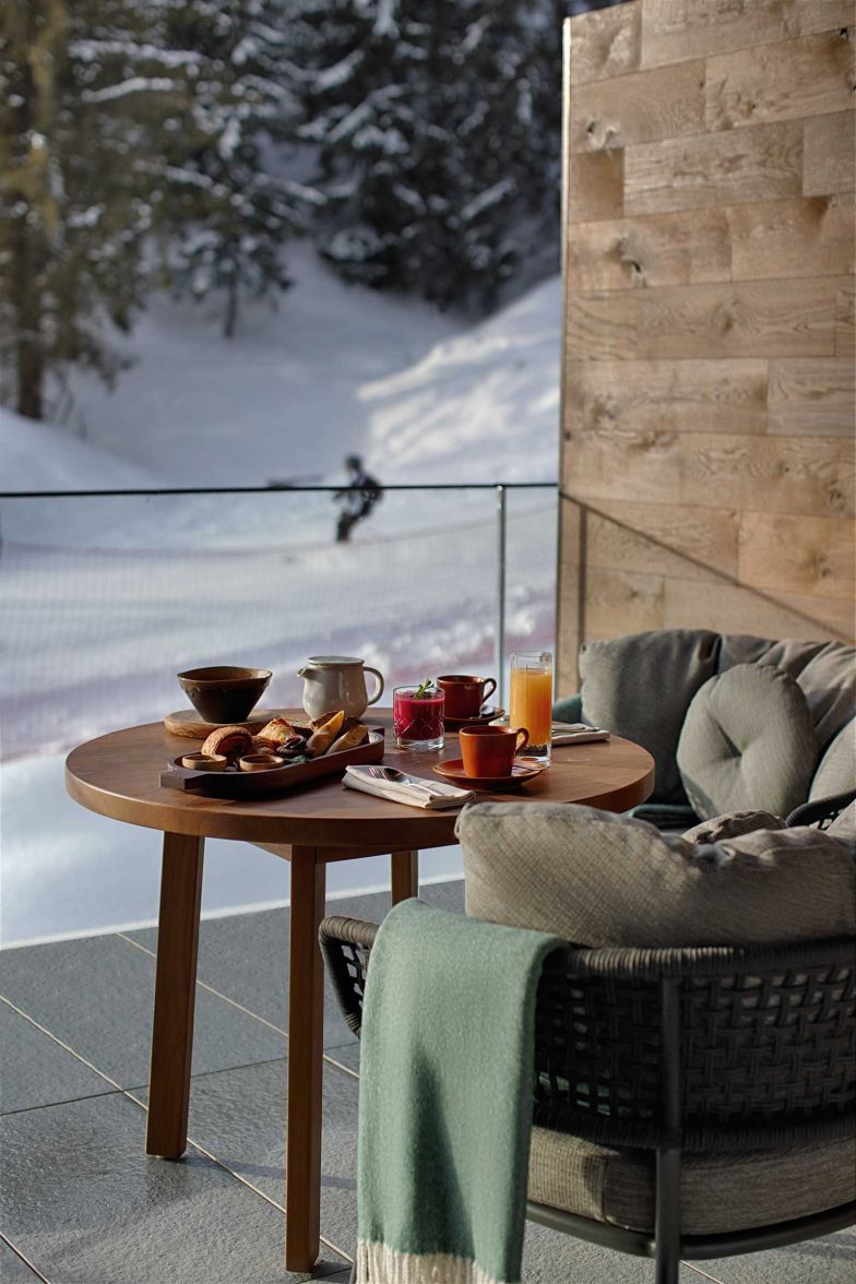 Gäste können Frühstück oder Snacks auf der Terrasse ihrer Zimmer geniessen, die mit eleganten Talenti-Möbeln der Kollektion «Moon» ausgestattet sind. Diese Möbel zeichnen sich durch ihre geschwungenen Linien und den warmen Farbton des Teakholzes aus, ergänzt durch geflochtene Seilkordeln, die eine handwerkliche Note verleihen.