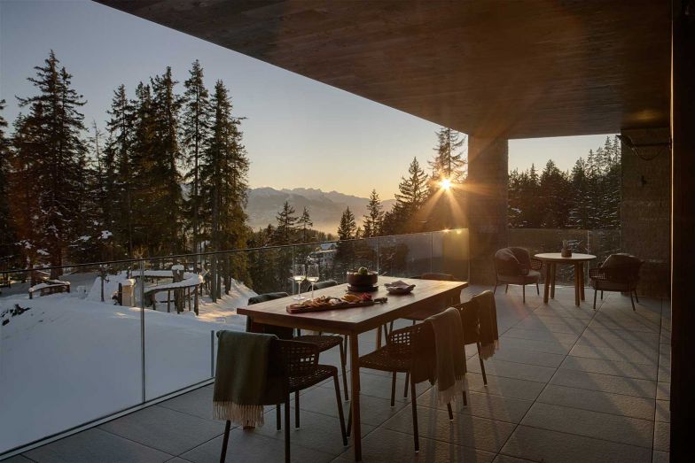 Die 78 Terrassenzimmer und Suiten bieten ein modernes Chalet-Gefühl, umgeben von Natur und Pinienwald. Bodentiefe Fenster und private Terrassen verstärken die Verbindung zur Umgebung.