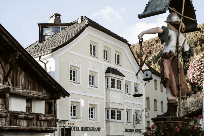 Burgeis liegt 1200 Meter über Meer an einem Berghang der Malser Heide unweit der Grenze zur Schweiz. Auf den ersten Eindruck wirkt der historische Gasthof wie einer von vielen in der Gegend. Aber die Kombination mit dem historischen Ansitz und dem Neubau machen das Ensemble zu einer echten Perle.