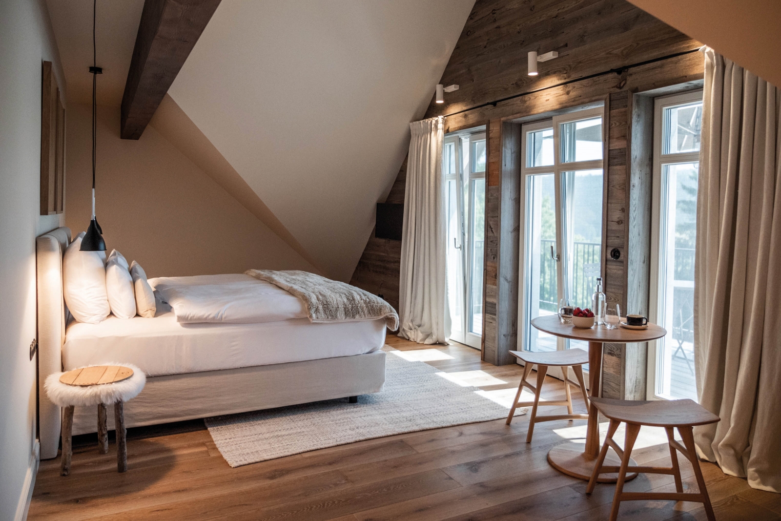 Eine Junior-Suite unter dem Dach mit Penthouse-Feeling findet sich in Loge 8, die in sanften Weiss- und Beigetönen gehalten ist. Hier schläft man in Betten der Manufaktur Schramm. Vom eigenen Balkon aus blickt man auf Wiesen, Hügel bis hin zu den Allgäuer und österreichischen Bergen.